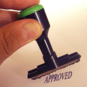 A rubber stamp printing the word approved