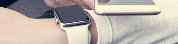 man in a white long sleeved top wearing a white apple watch holding an iPhone next to it on his left wrist
