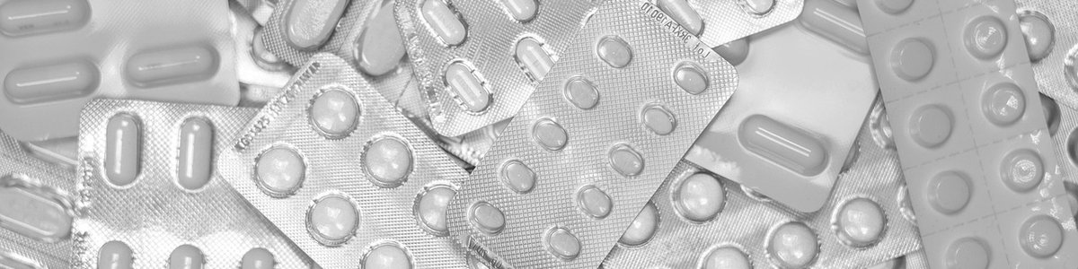 Piles of pill packets containing white pills.